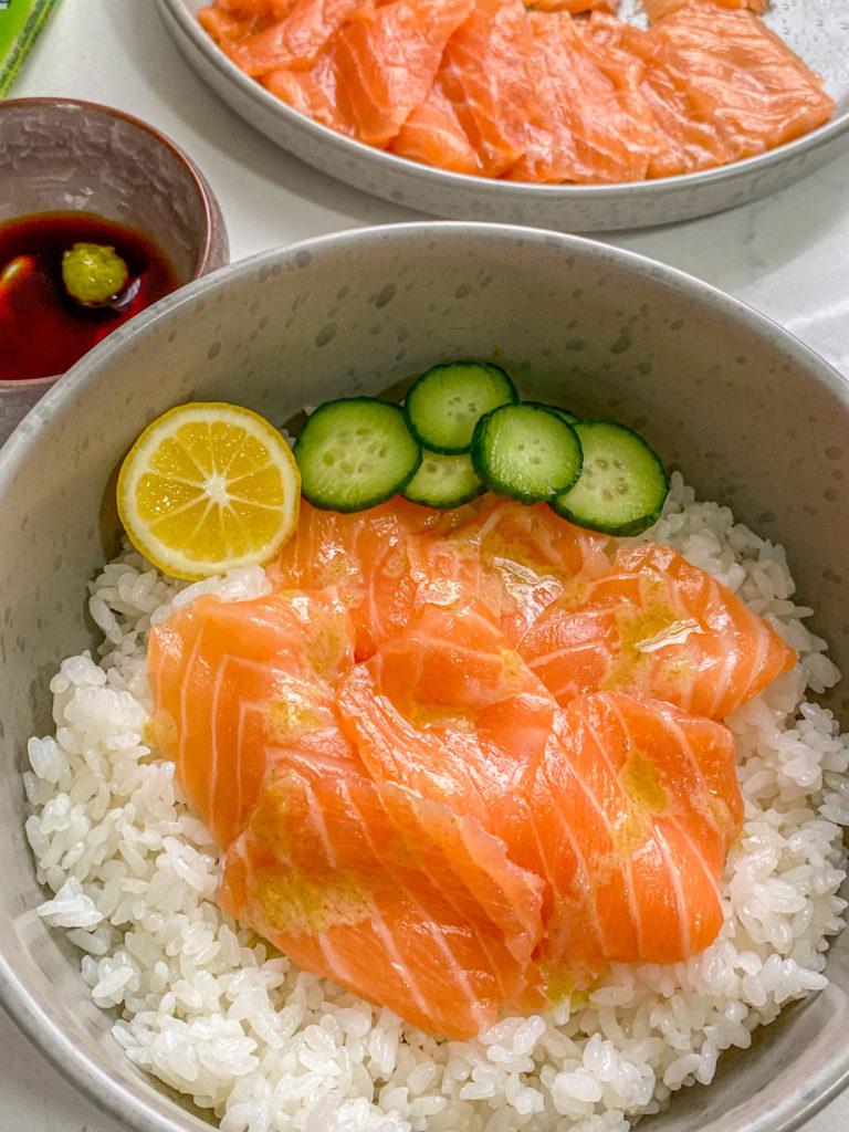 salmon sashimi or sushi grade salmon sliced thin with rice, cucumbers, soy sauce and wasabi